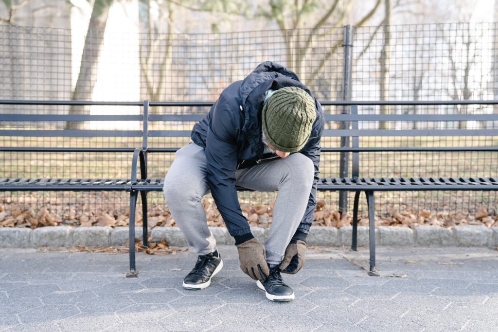 Stijve gewrichten en spieren - Man strikt zijn veters